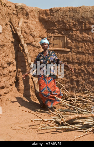 Village woman, Larabanga, Ghana, having just used a ridgid ladder made from tree trunk to get down from her house roof. Stock Photo