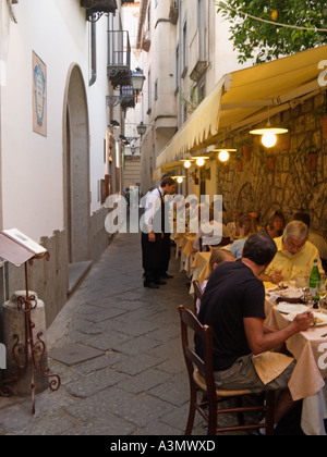 People eating at a busy restaurant in Sorrento's charming narrow streets, Sorrento, Bay of Naples, Amalfi Coast, Italy Stock Photo