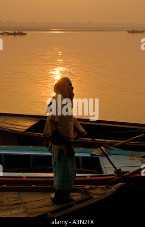 Sunrise and boatman on the Ganges River, Varanasi, India Stock Photo