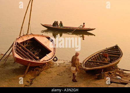 Boats on shore of Ganges River at dawn, Varanasi, India Stock Photo