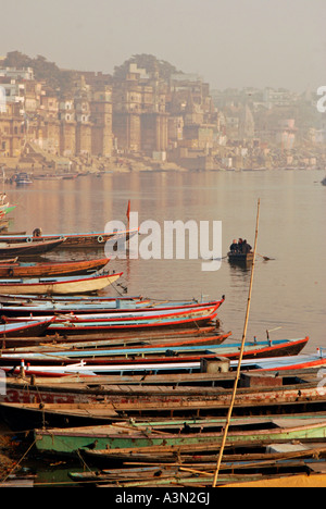 Boats on shore of Ganges River at dawn, Varanasi, India Stock Photo