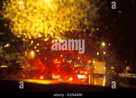 Raindrops on the windshield. Looking outside from interior of a car driving on a rainy night in Manhattan New York. Stock Photo