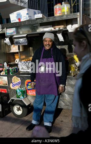 Middle eastern man selling hot dogs by his cart on 6th Avenue on New York USA january 2006 Stock Photo