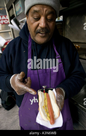 Middle eastern man selling hot dogs by his cart on 6th Avenue on New York USA january 2006 Stock Photo