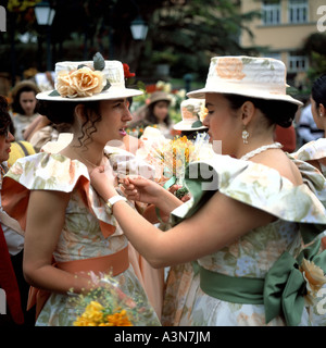 TWO YOUNG WOMEN WITH FLOWERY DRESS AND HAT AT SPRING FLOWER FESTIVAL  FUNCHAL  MADEIRA  ISLAND PORTUGAL Stock Photo