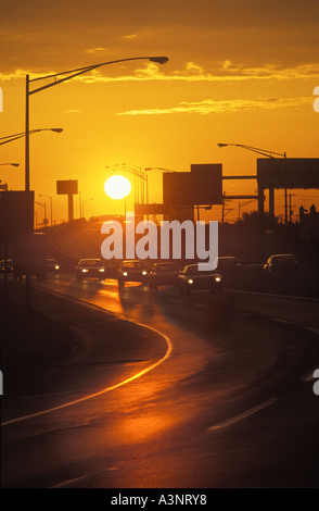 Cars And Trucks In Daily Traffic Commute On Curved Highway At Sunset With Sun,  Philadelphia PA USA Stock Photo
