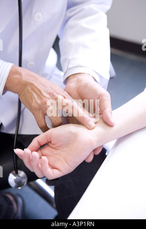 Doctor taking pulse of a patient Stock Photo