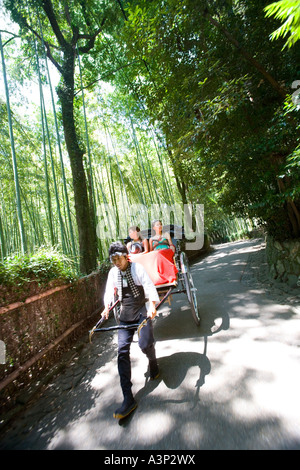 Two young women sitting in rickshaw in Sagano, Kyoto, Japan Stock Photo