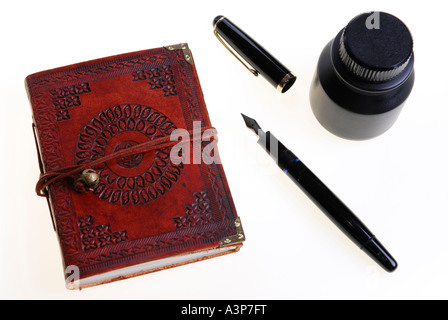 top view of Leather personal diary and ink bottle with fountain pen on white background Stock Photo