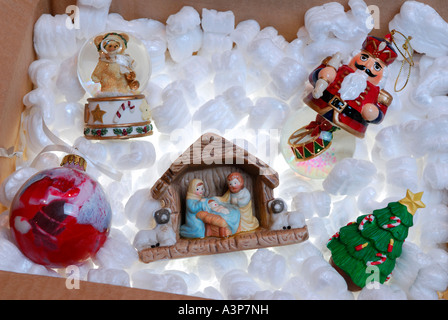 Nativity set and Christmas ornaments stored in a box of backlit styrofoam Stock Photo