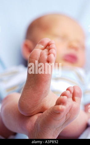 Newborn baby sleeping with feet in foreground Stock Photo