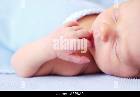 Closeup of newborn baby sleeping on blue blanket Stock Photo