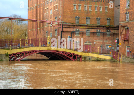 High water at Quay Street Bridge Decorated Iron bridge and Healings Flour Mill during Flood Stock Photo