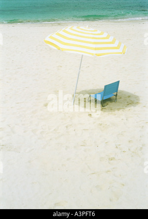 Parasol and folding chair on beach Stock Photo