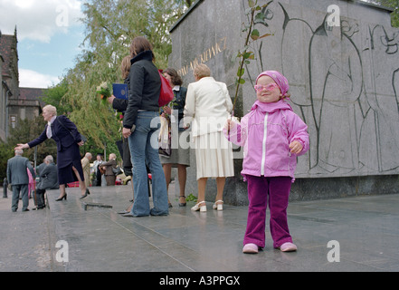 Little girl with a rose near the Adam Mickiewicz statue in Poznan, Poland Stock Photo
