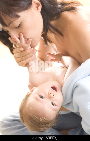 mother kissing baby's hand Stock Photo