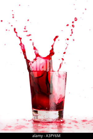 Ice cube dropped into a glass of grape juice Stock Photo