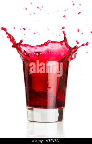 Ice cube dropped into a glass of grape juice Stock Photo