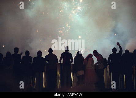 Starting firework rockets and silhouettes of spectators Stock Photo