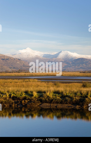 Afon Glaslyn River and Glaslyn Marshes Site of Special Scientific Interest with snow on mountains  Porthmadog Gwynedd Stock Photo