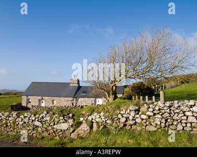 Traditional single storey traditional stone cottage with slate roof tiles stone wall in rural hamlet on Lleyn Peninsula Stock Photo