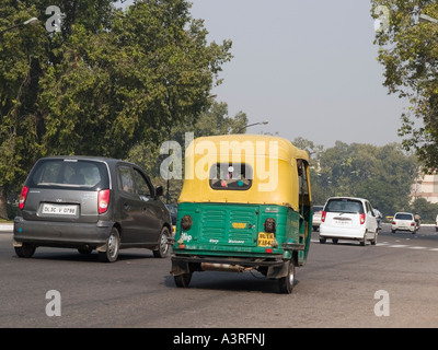 Traffic on busy road with green and yellow auto rickshaw fueled by Compressed Natural Gas CNG New Delhi Uttar Pradesh India Stock Photo