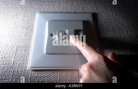BRITISH DOUBLE DOMESTIC LIGHT SWITCH  BEING TURNED ON / OFF  RE ENERGY ELECTRICITY BILLS COSTS RISING SAVING UK Stock Photo