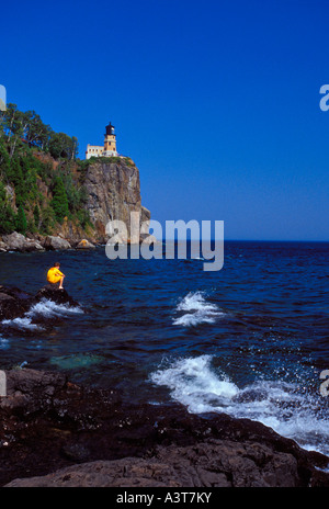 a-boy-explores-the-rocky-shore-below-the-split-rock-lighthouse-at-split