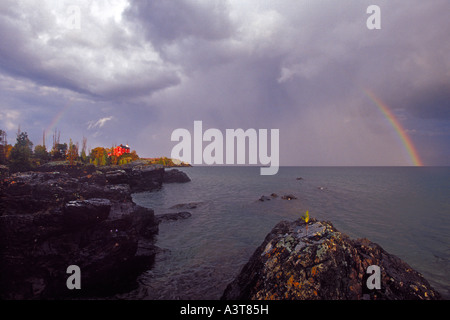 A rainbow arches over the Marquette Lighthouse in Marquette Michigan on Lake Superior Stock Photo