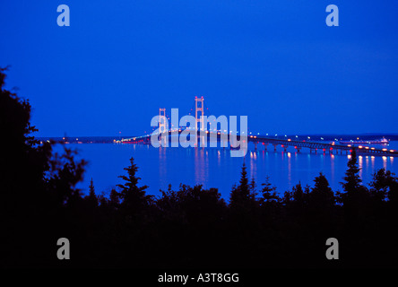 A FREIGHTER APPROACHES THE MACKINAC BRIDGE AT NIGHT AS SEEN FROM STRAITS STATE PARK NEAR ST IGNACE MICHIGAN Stock Photo