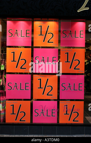 Shop windows with posters advertising half price sale Stock Photo