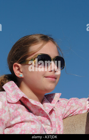 Young girl aged 12 years old wearing sun glasses and pink blouse Stock Photo