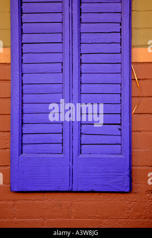 Blue shutter with yellow ribbon on red brick building Stock Photo