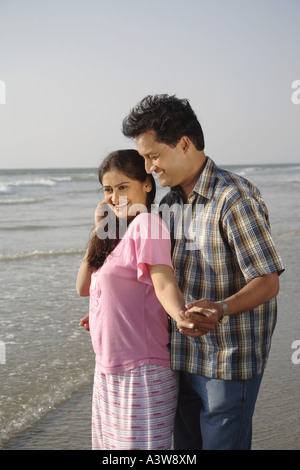 Couple standing on beach lovingly enjoying sun sea and sand Stock Photo