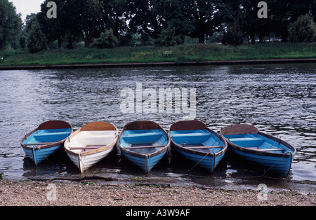 Five rowing boats along the shore of the River Thames Hampton Court Middlesex England UK Stock Photo