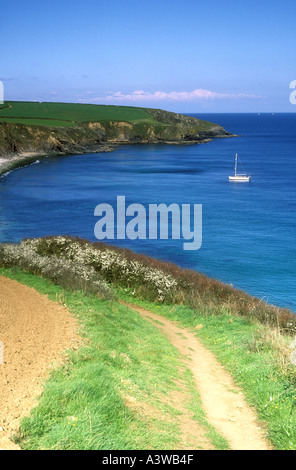 Yacht moored off Porthbeor Beach on the Roseland Peninsula in Cornwall, UK Stock Photo