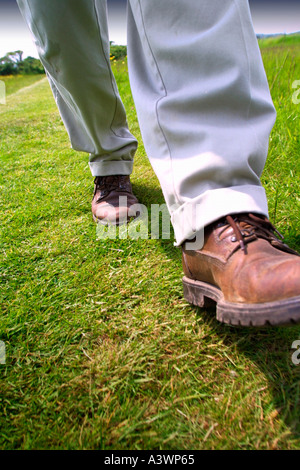 Close up of legs and boots walking on grass Isle of Wight England UK Stock Photo