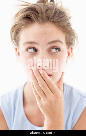 Portrait of a brunette woman covering half her face with a fern leaf ...