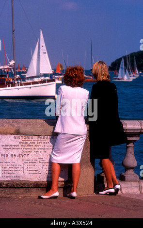 Women spectators in skirt suits watch yacht racing Cowes Isle of Wight England Stock Photo