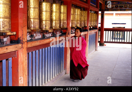 Buddhist devotee spinning prayer wheels at Gong Tang pagoda in Labrang or laburang Si monastery in Xiahe Gansu Province China Stock Photo