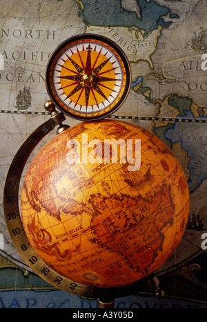 Old compass sitting on top of old globe Stock Photo