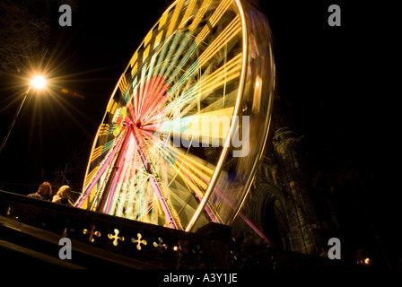 dh Street fairground PRINCES ST GARDENS EDINBURGH Large Ferris wheel ride Winter wonderland funfair New Year time at night christmas people carousel Stock Photo