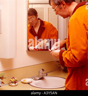 Young man prepares to brush his teeth in his bathroom Stock Photo