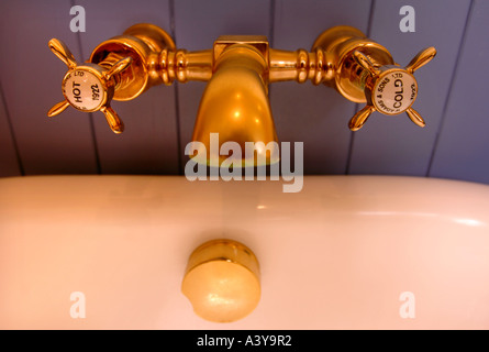 GOLD MIXER TAPS IN A LUXURY BATHROOM Stock Photo