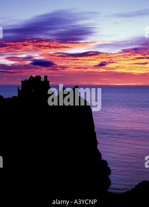 Portrait format image of a silhouetted Dunnottar castle near stonehaven north east scotland Aberdeen with vibrant sunrise skies. Stock Photo