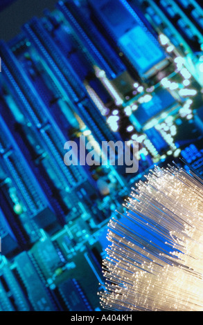 Close-up of fibre optic cables with computer printed circuit board in the background Stock Photo