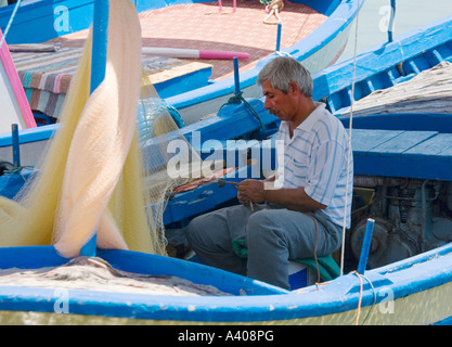 Fisherman fixing net Alanya Harbor Turkey Stock Photo