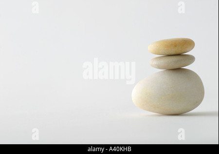 Three pebbles balanced with a white background. Stock Photo