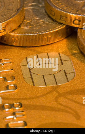 Pound coins on a chip and pin gold credit card, showing the chip Stock Photo