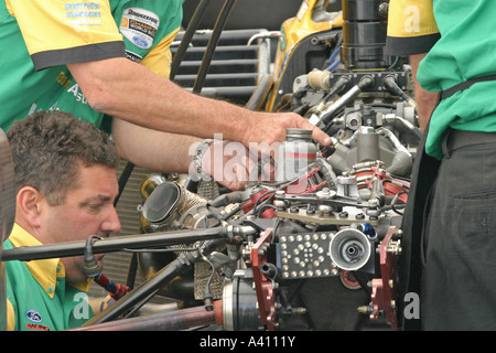 mechanics concentrating on adjusting racing car engine Stock Photo